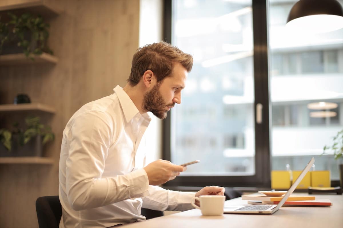 Salesman on mobile device in White Dress Shirt