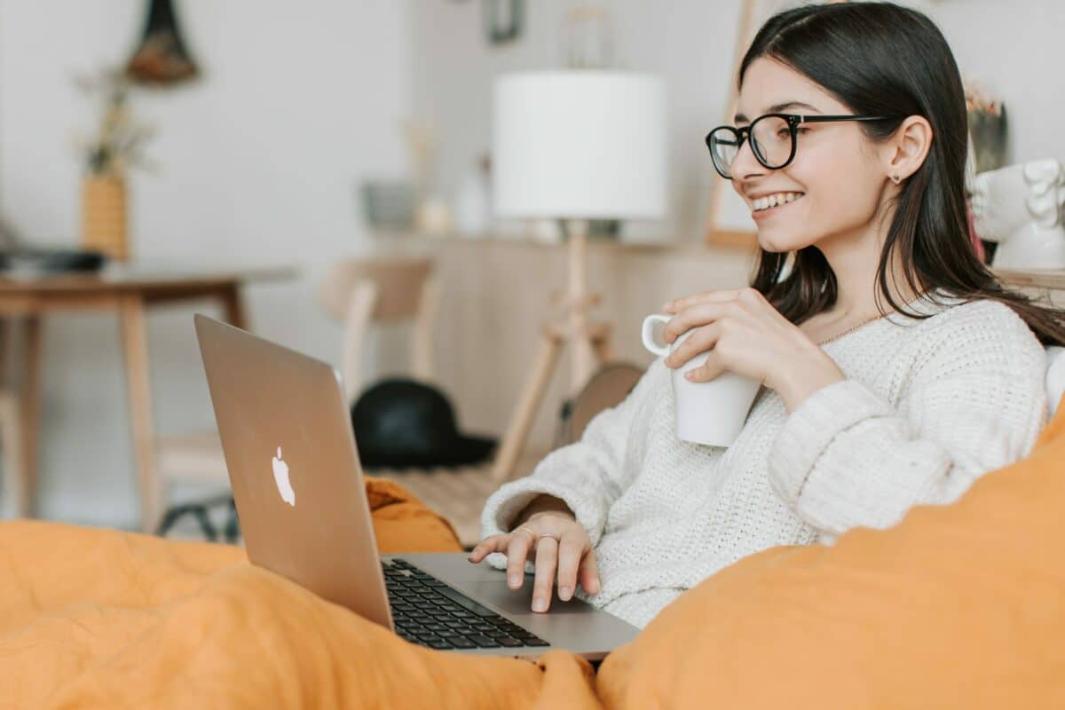 Smiling woman looking at black friday deals on laptop