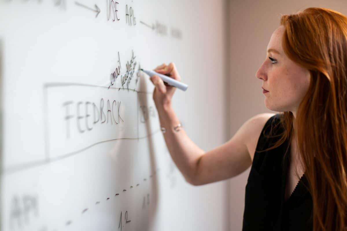 Woman writing on whiteboard notes about vendors